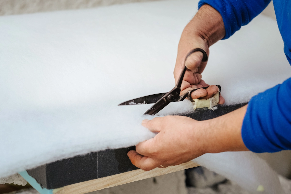seorang teknisi sedang memotong flexible polyurethane foam